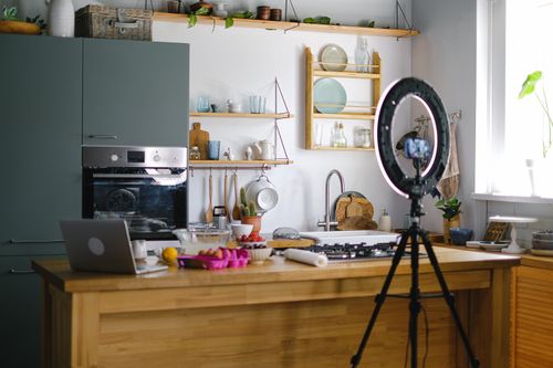Free Contemporary kitchen interior with baking setup, laptop, and ring light, perfect for content creation. Stock Photo
