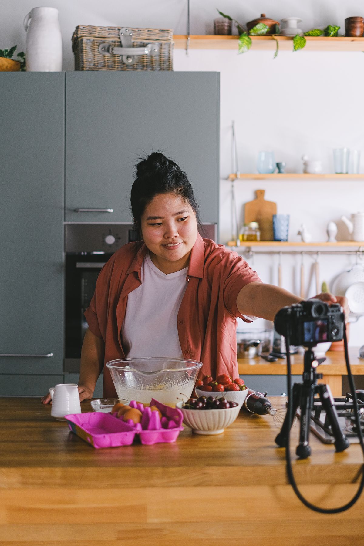 Food creator filming a cooking tutorial in a modern kitchen
