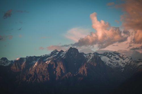 Free Beautiful snowcapped mountains with pink clouds during sunset. Stock Photo