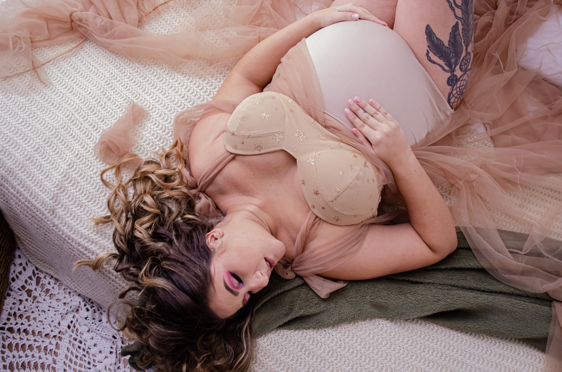 Pregnant woman resting peacefully on a bed in a calm home setting