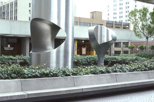 Free Contemporary metal sculptures in a cityscape surrounded by greenery. Stock Photo