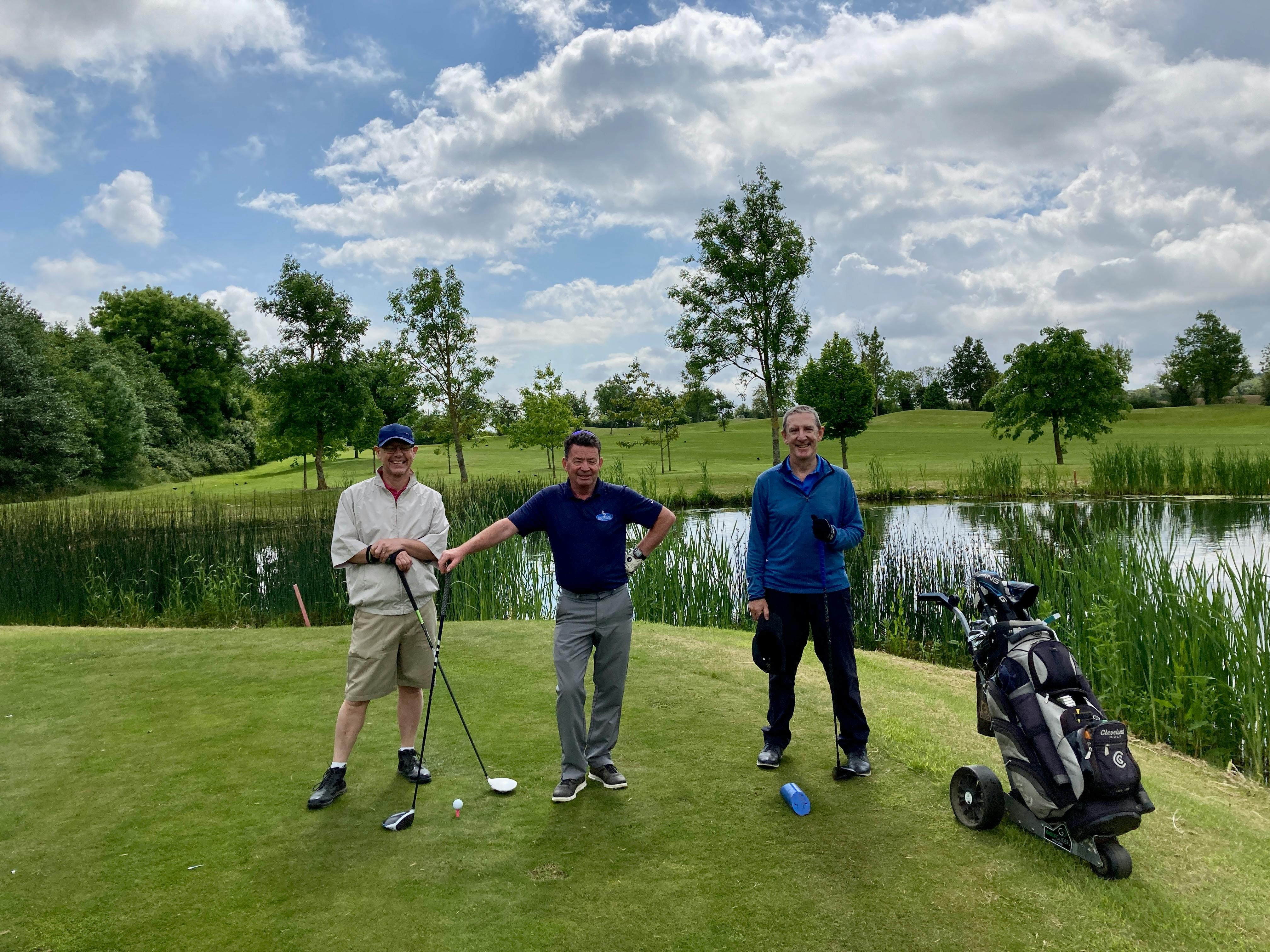 golfers standing near the lake