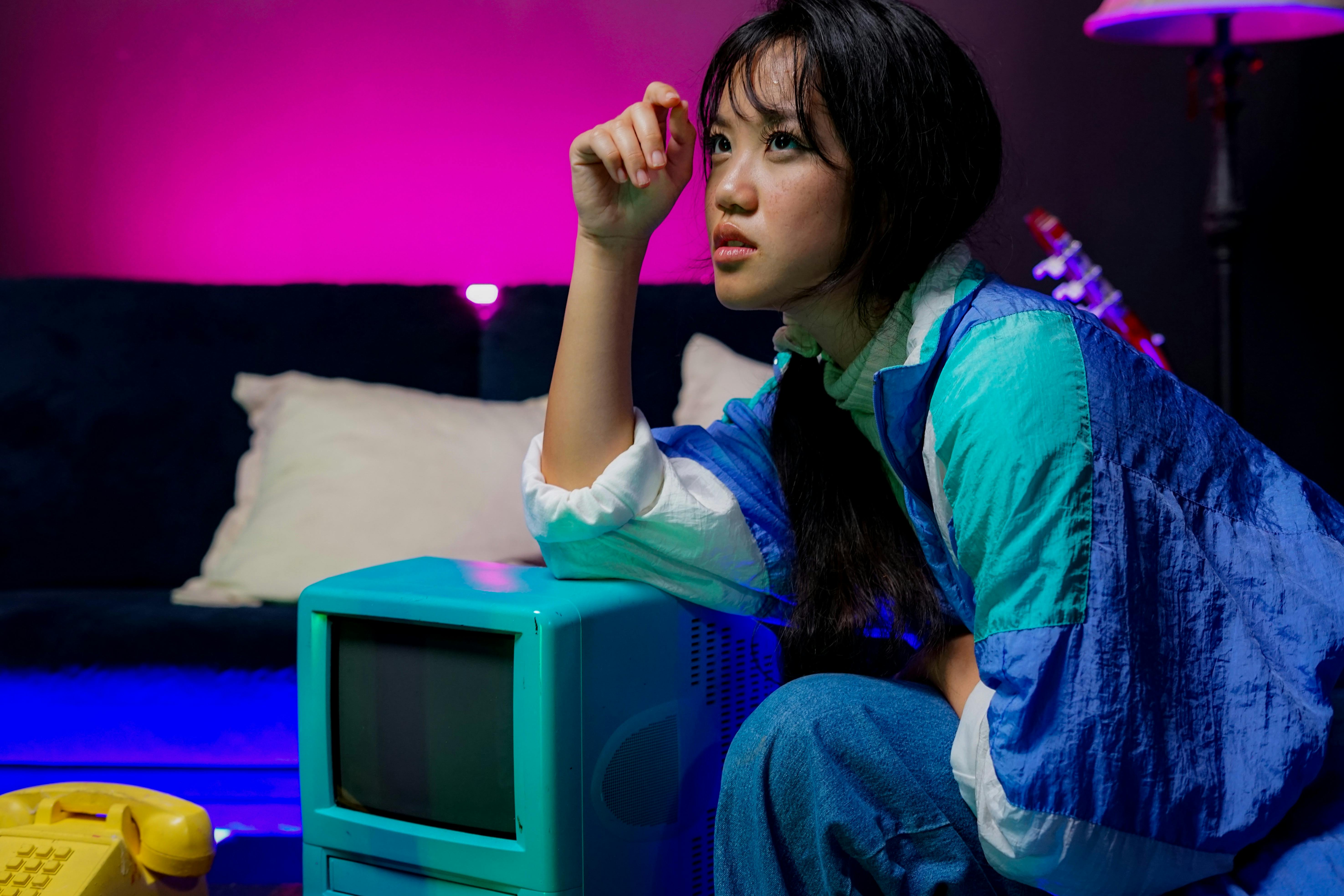 Portrait of a woman in retro style with neon lighting and vintage television, evoking the 90s era.