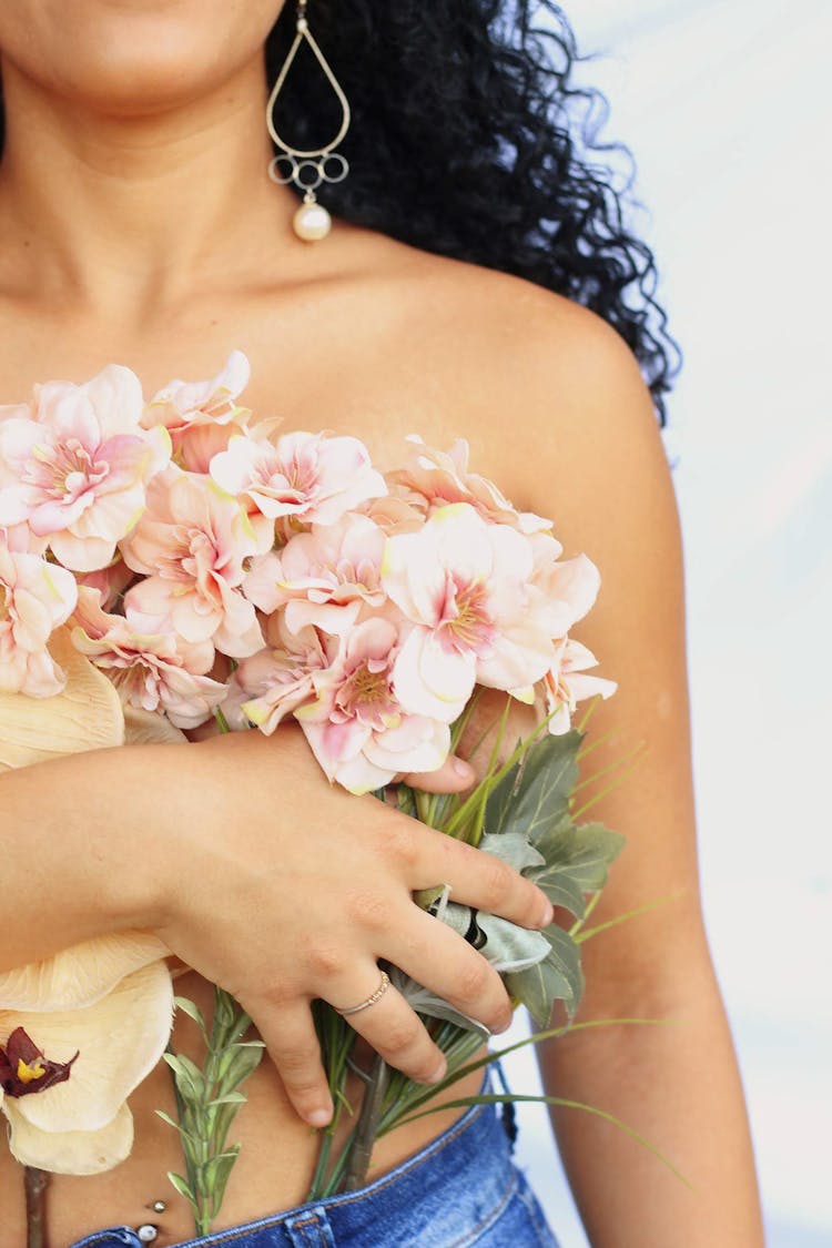 Shirtless Woman Holding A Bouquet Of Flowers