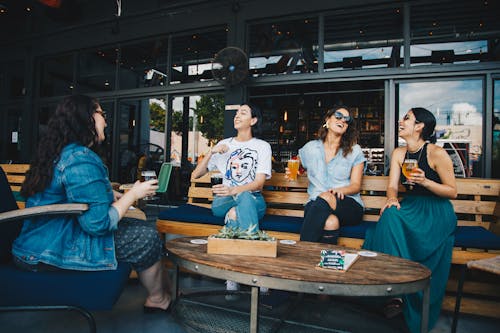 Quatro Mulheres Conversando Sentadas No Banco