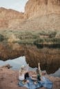 两名妇女在宁静的湖边野餐，欣赏着岩石峡谷的景色