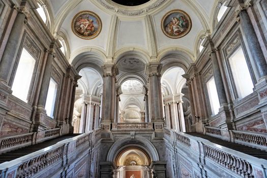 Majestic interior of the Royal Palace of Caserta featuring grand staircases and ornate architecture.