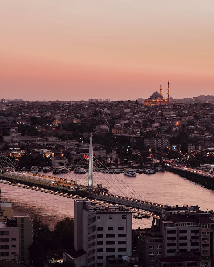 City Waterfront With Suspension Bridge At Pink Dusk