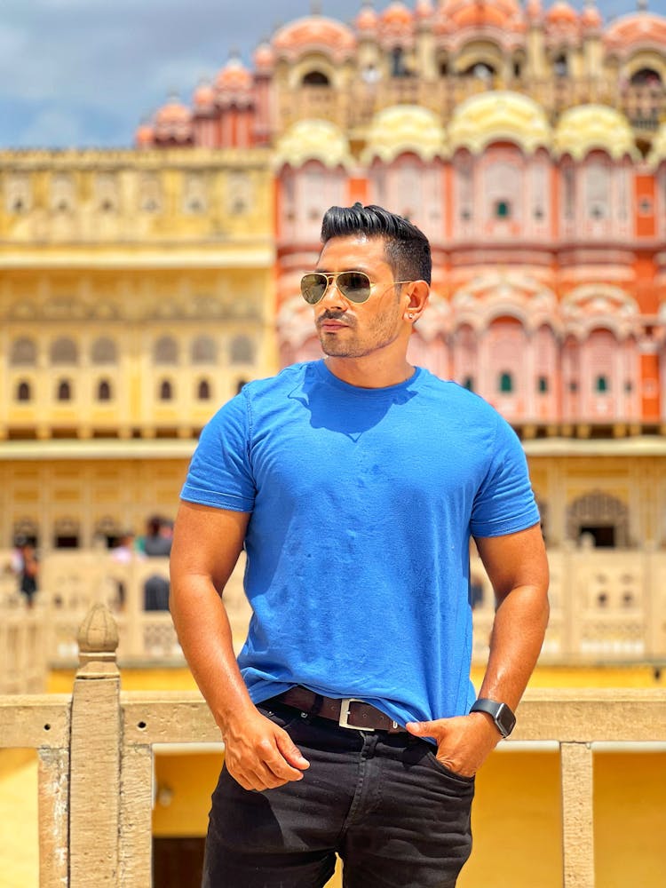 Stylish Man In Sunglasses Posing Near Traditional Building