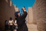 Tourists capturing the beauty of ancient brick ruins on a sunny day, showcasing cultural exploration.