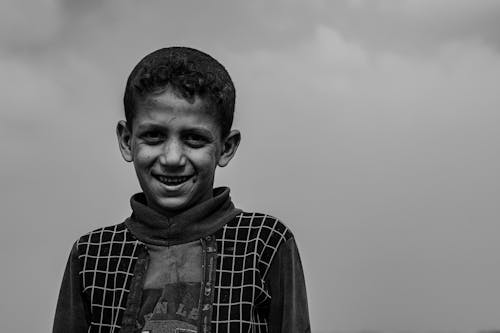 Grayscale Photo of a Smiling Boy