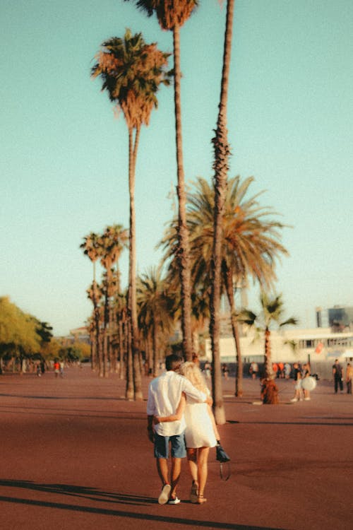 A Couple Walking Together on a Public Park with Palm Trees