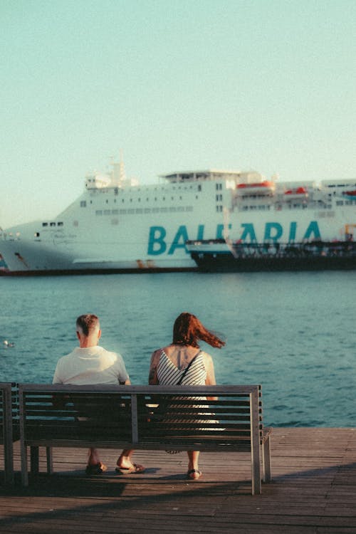 People Sitting on a Bench by a Sea