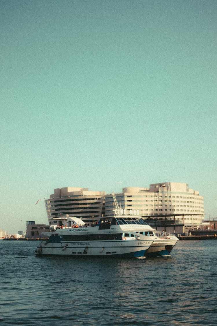 Recreational Boat On Sea And Waterfront With Modern Building