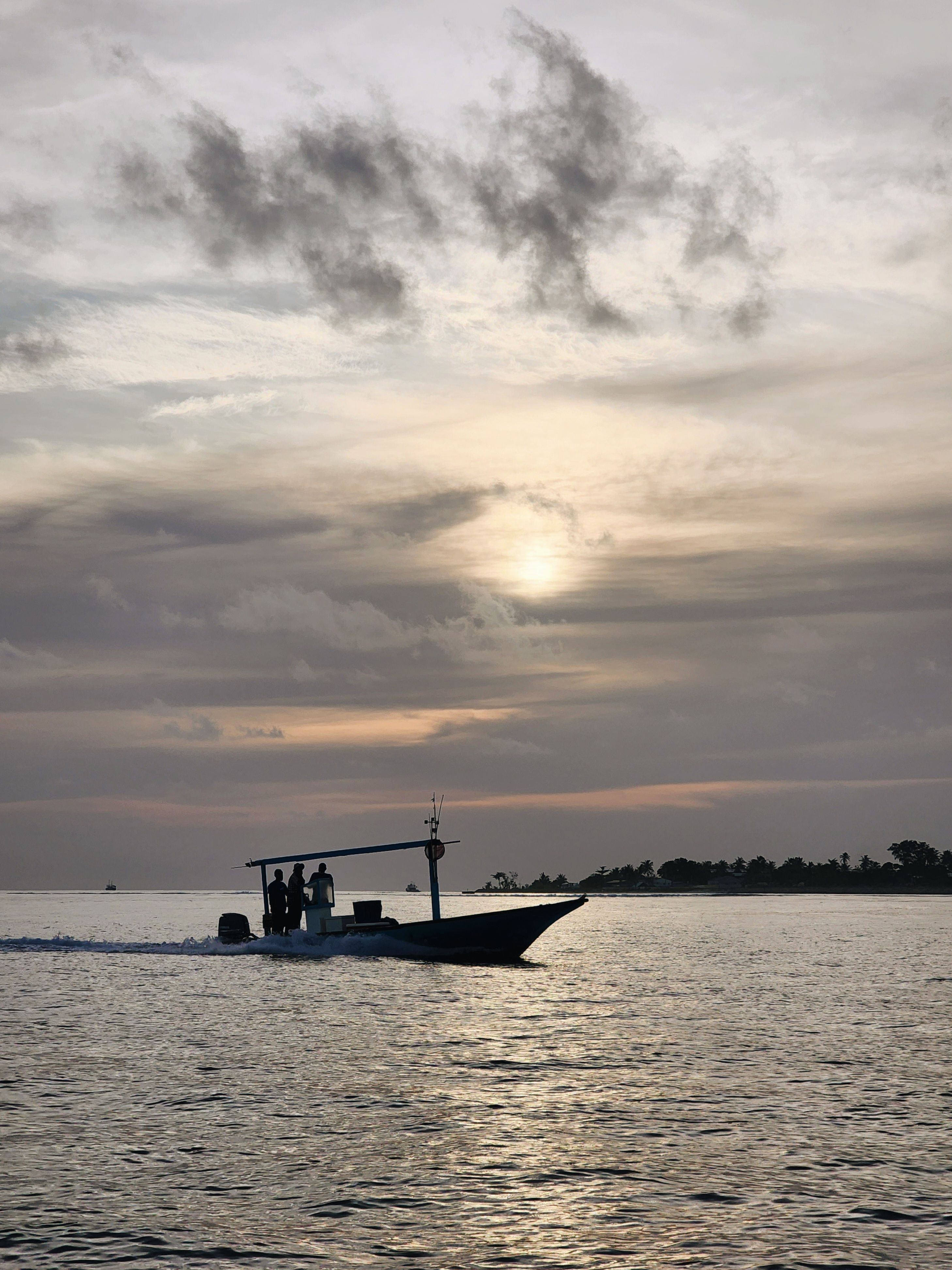 Silhouette of People Standing on a Motorboat · Free Stock Photo