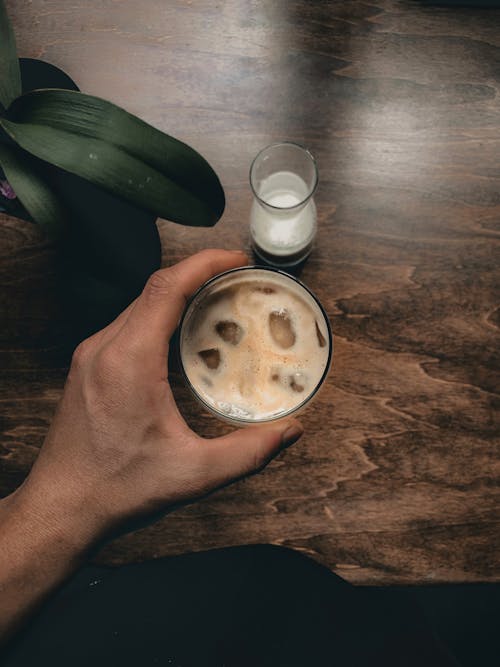 Person Holding a Glass of Drink with Ice