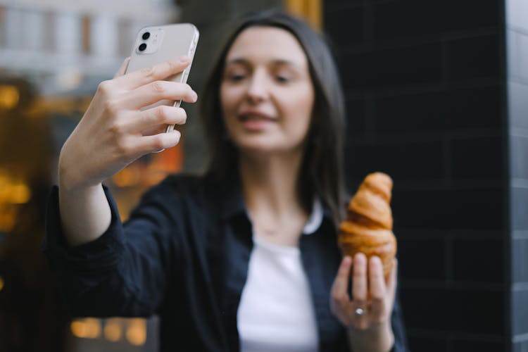 Food Vlogger Holding A Croissant