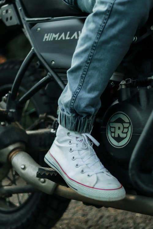 Free Person Wearing Blue Denim Jeans and White Converse All Star High Top Sneakers Stock Photo