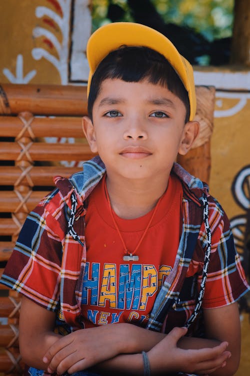 A Boy Wearing a Yellow Cap and a Plaid Top