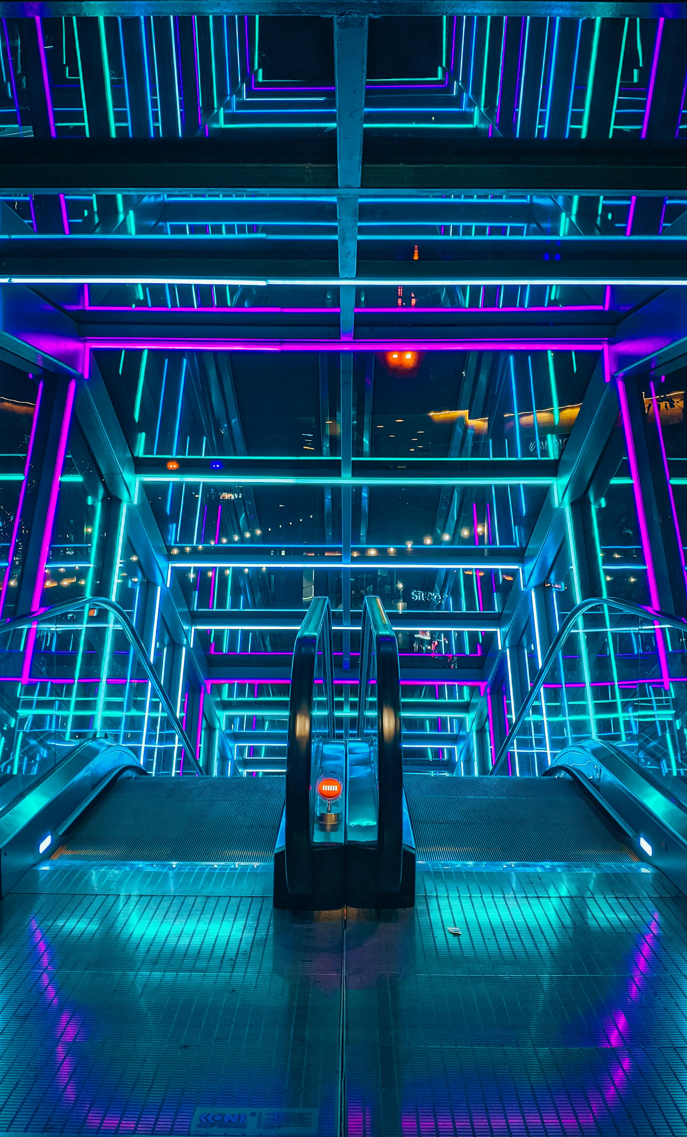 A vibrant and colorful illuminated escalator with a modern architectural design.