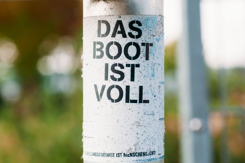 Close-up of graffiti 'Das Boot Ist Voll' on a post in Bubenreuth, Germany.