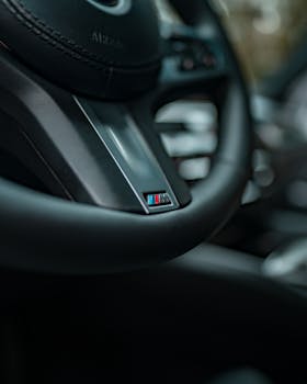 Close-up view of a luxury car steering wheel showing brand detail.