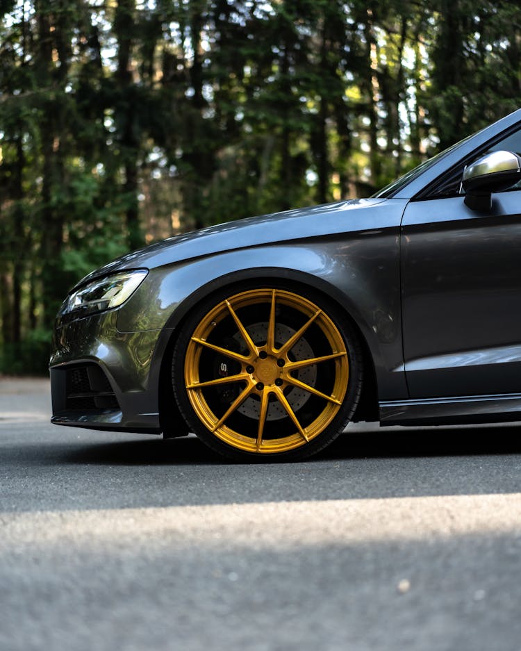 Black Sedan Car With Yellow Tire Parked On The Road