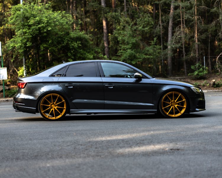 Black Car With Gold Rims Parked On The Road