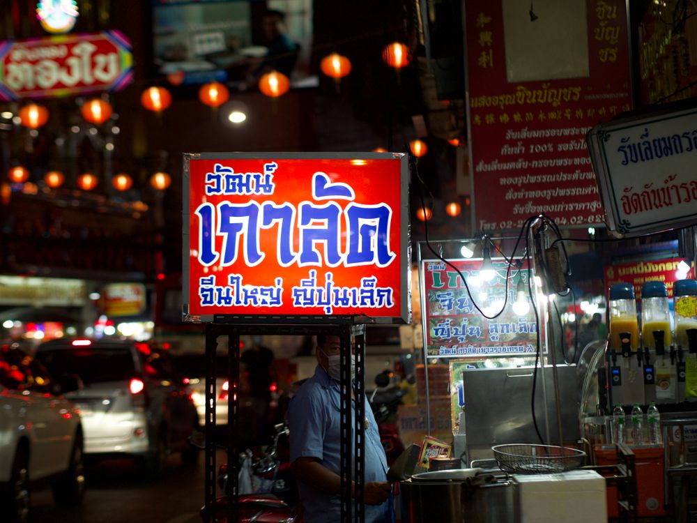 Thai script signs lit up at a night street market