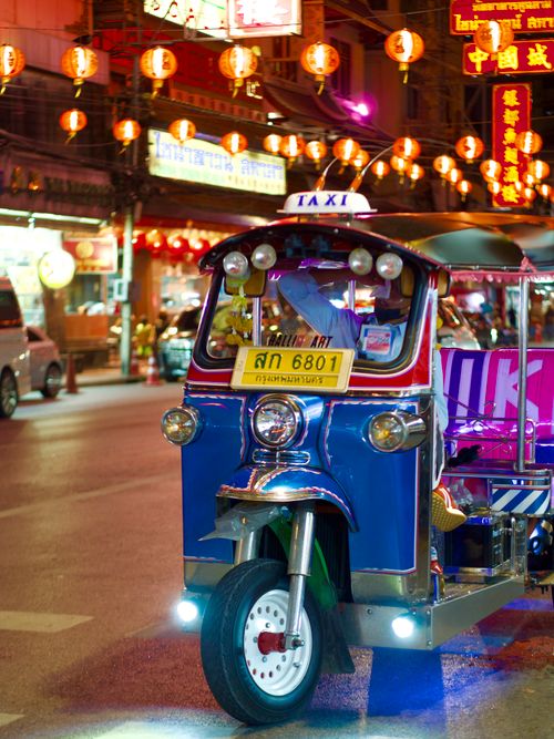 Free A colorful tuk-tuk under Chinese lanterns in Bangkok's bustling night market. Stock Photo