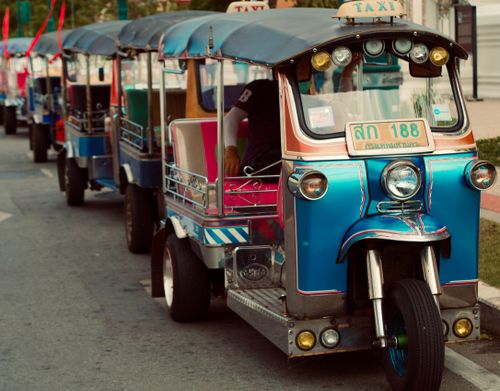 Free Colorful tuk-tuks parked in a row on a street, showcasing urban transportation. Stock Photo