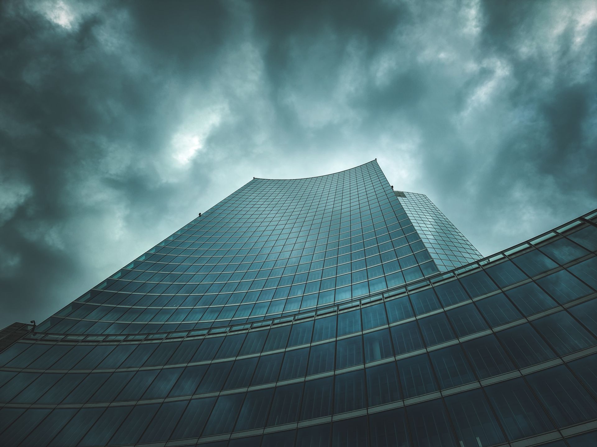 Fachada de torre de oficinas moderna bajo cielo nublado