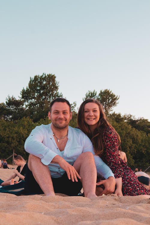 Couple Sitting on the Sandy Beach 