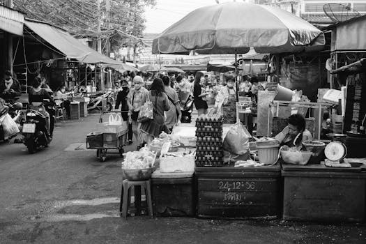 Capture of a busy wet market with various stalls and people in a monochrome setting.