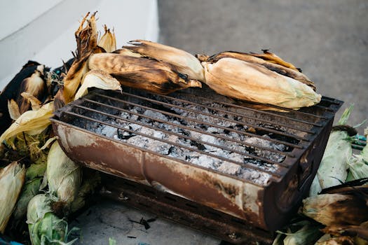 Charcoal grill with roasted corn, perfect for outdoor summer gatherings and barbecues.