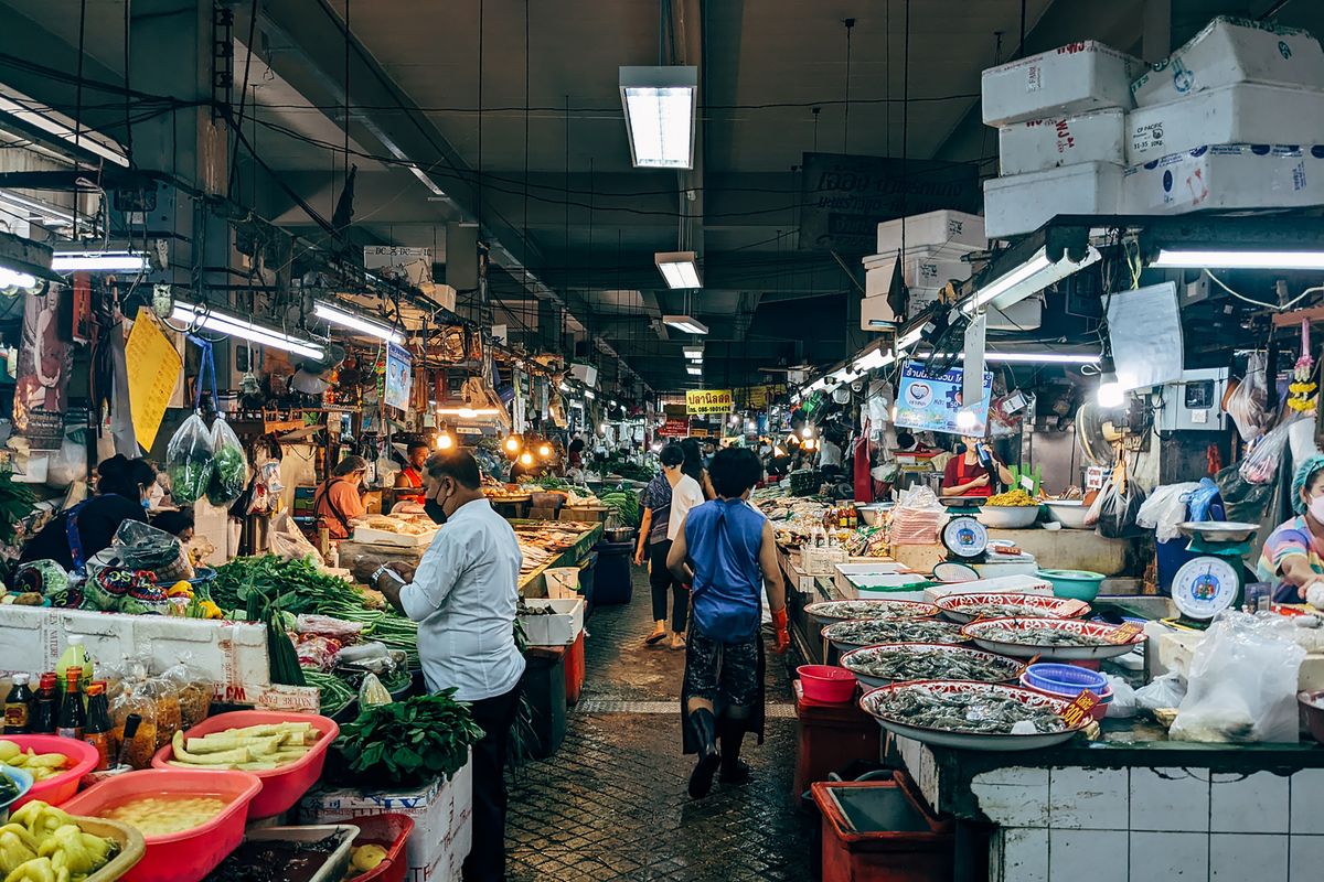 Pasar borong basah di Asia Tenggara dengan gerai hasil segar dan pembeli borong