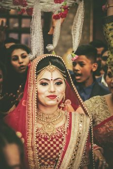 A vibrant Indian bride in traditional attire at a wedding ceremony in Dehradun. Captivating cultural expression.