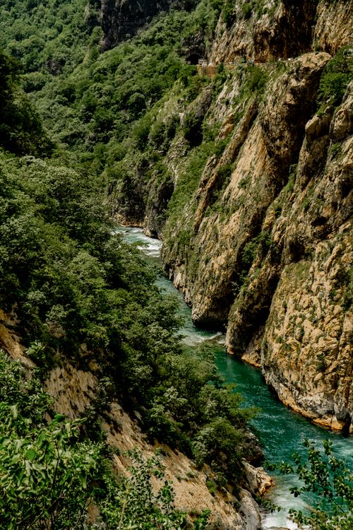 Free A breathtaking aerial view of a turquoise river winding through lush green cliffs. Stock Photo