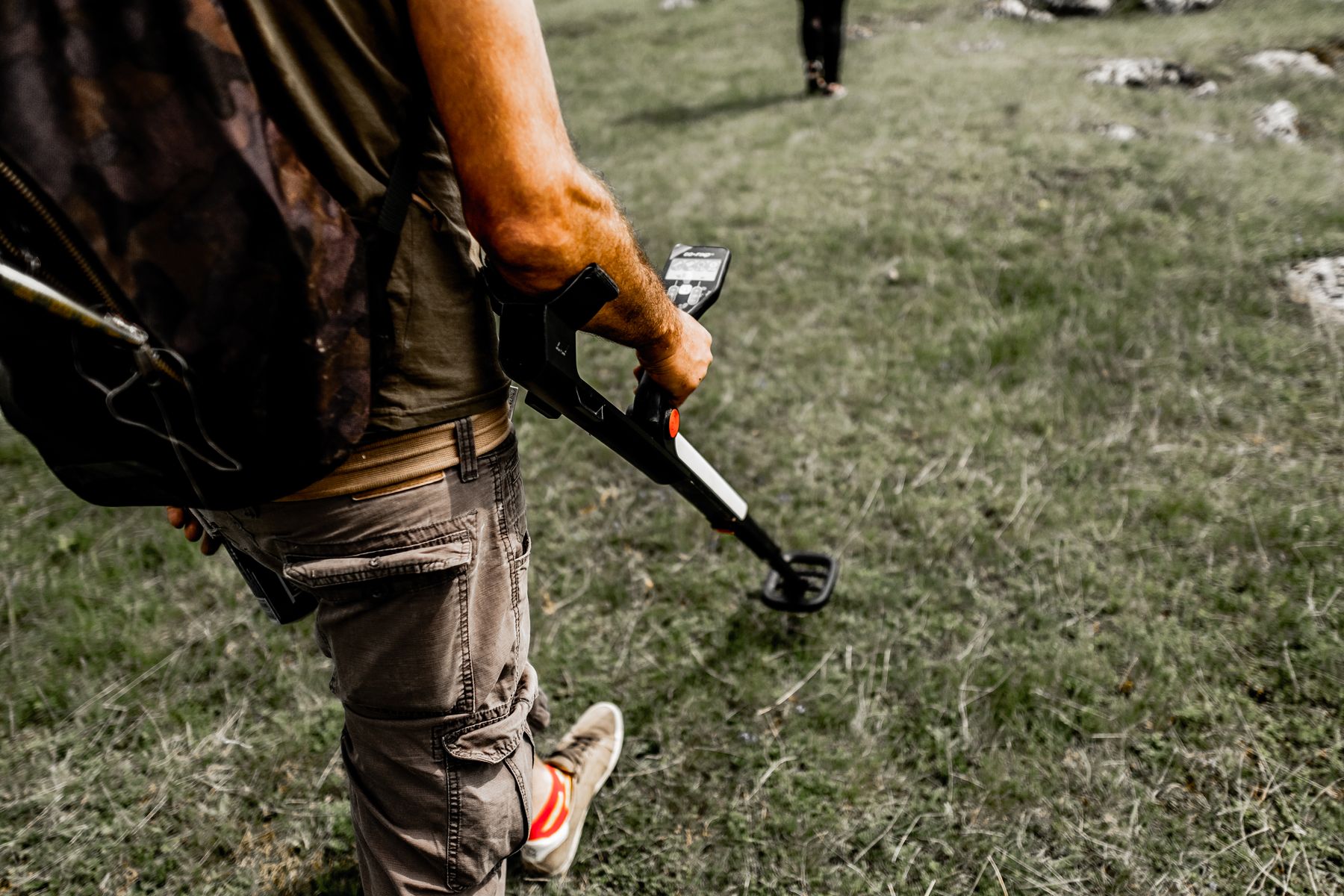 Person metal detecting in a field