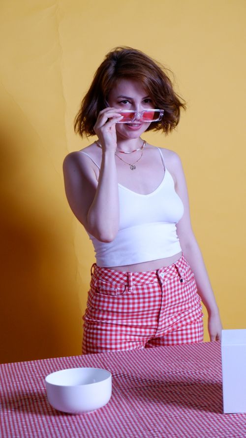 Free Confident woman in trendy sunglasses posing with yellow background in studio. Stock Photo