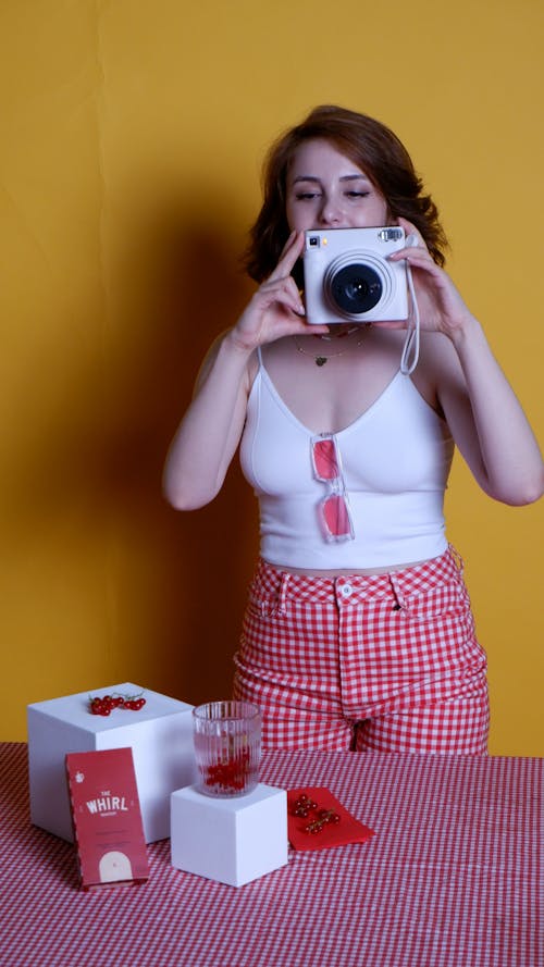 Woman Holding a Polaroid Camera