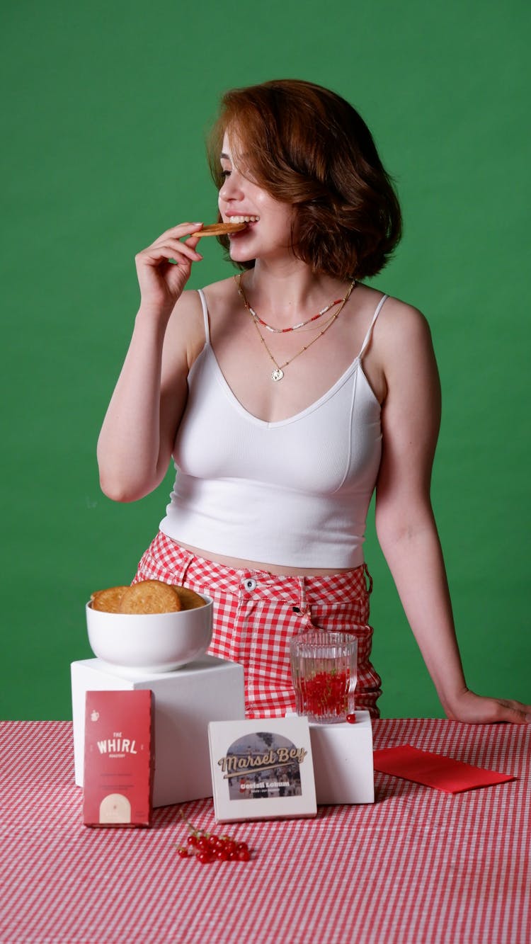 A Woman In White Tank Top Eating Biscuit