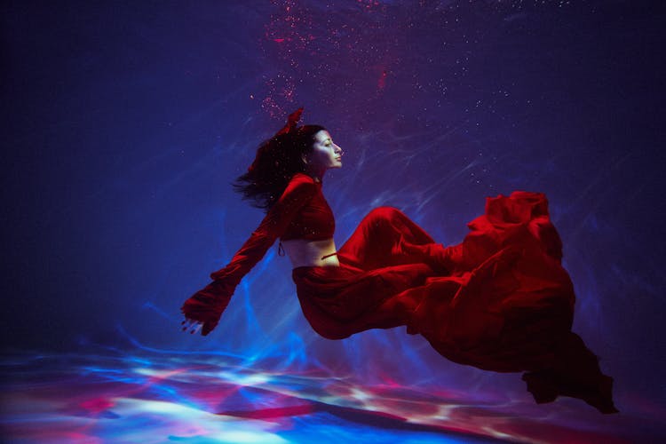 Woman In A Red Skirt Floating Underwater