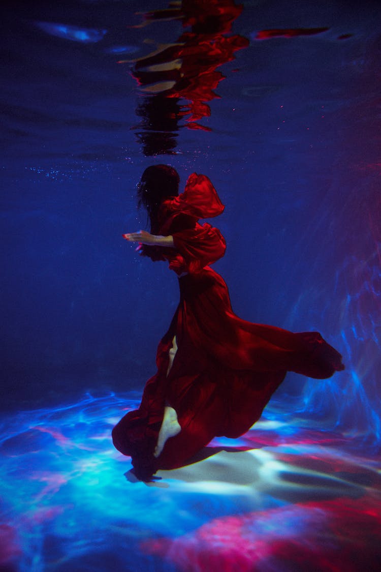 Woman Fashion Model In Red Dress Posing Underwater