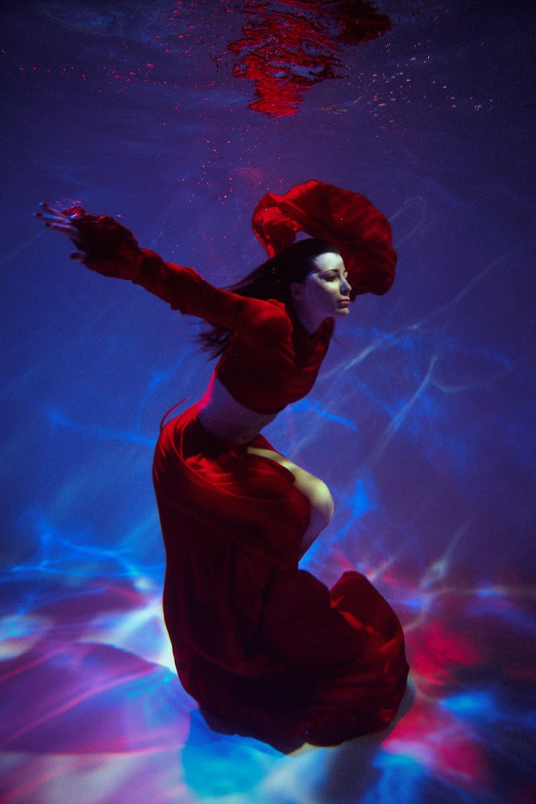 Woman In Red Clothing Floating Underwater