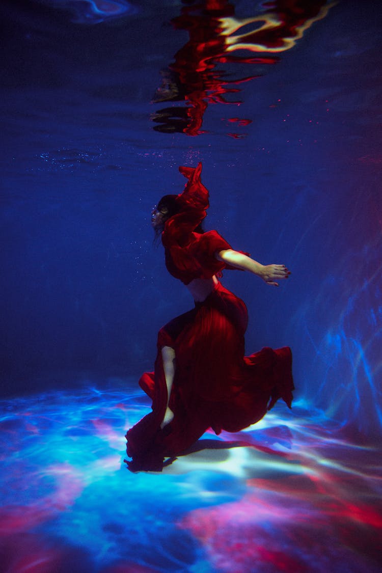 Woman In Red Dress Diving In Pool