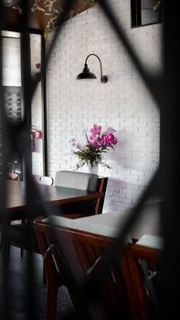 Intimate cafe interior with floral arrangement and vintage lighting, offering a warm ambiance.