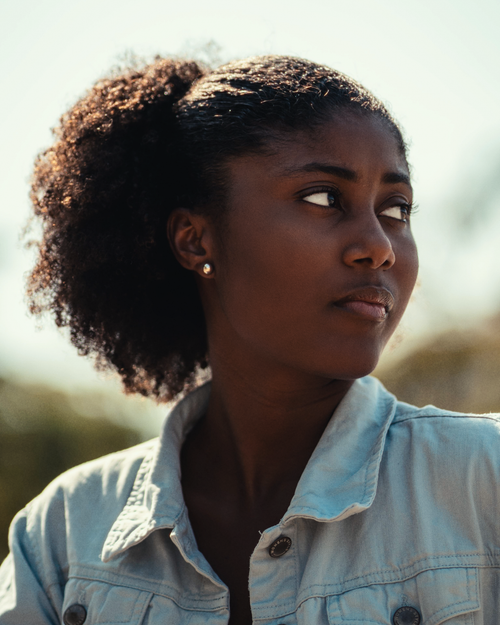 Free A serene portrait of an African-American woman looking sideways in natural light. Stock Photo