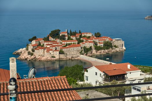 Charming coastal village on an island in the Adriatic Sea with red tiled roofs and serene blue waters.