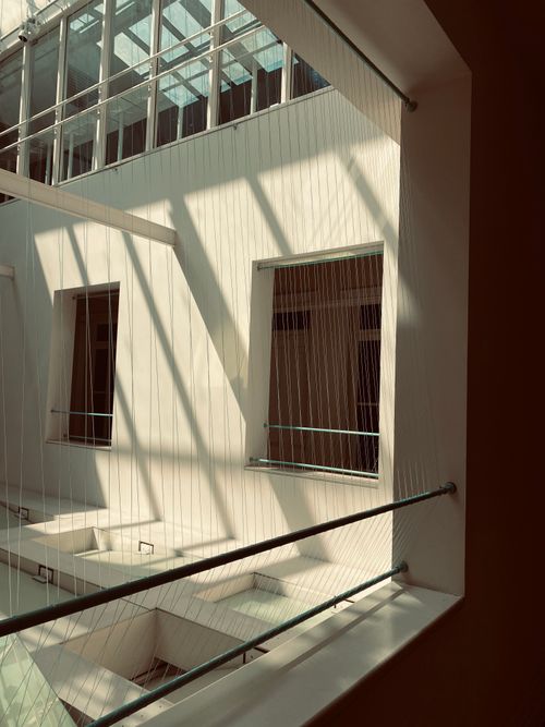 Free Elegant interplay of light and shadow in modern architectural design featuring large windows and railings. Stock Photo